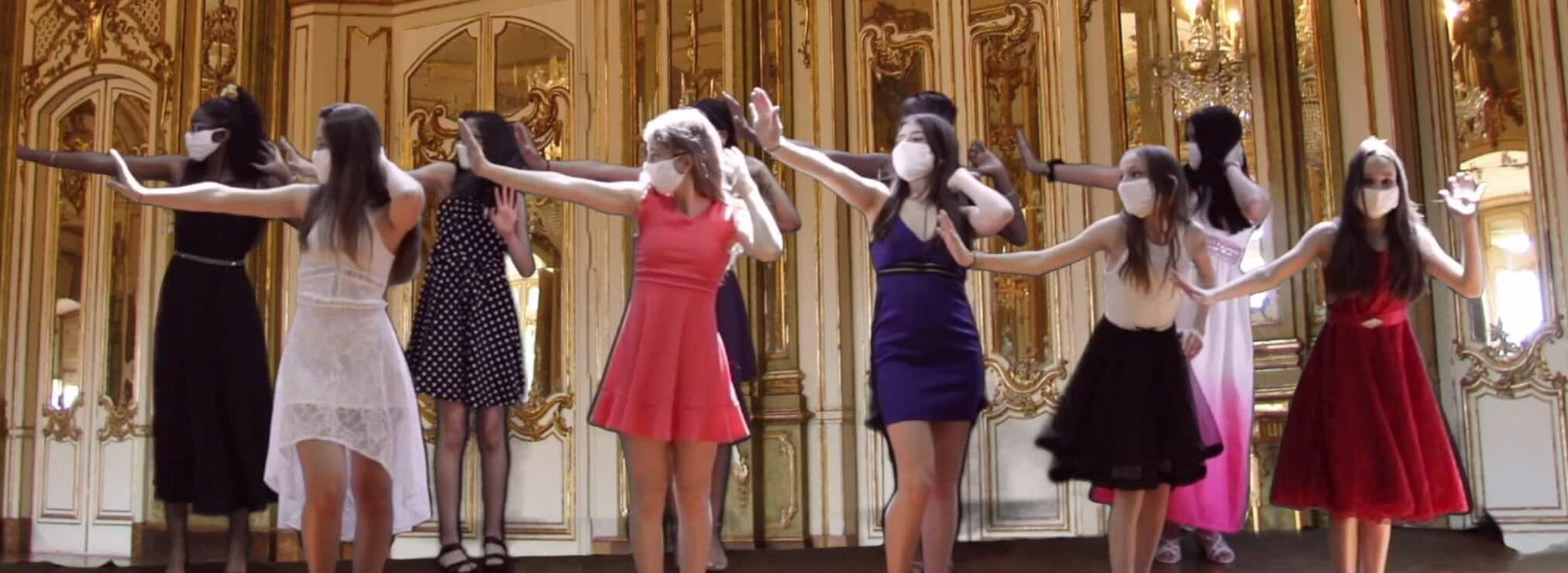 Girls wearing their dress and dancing over a fancy background on a scene from the musical Face a Face