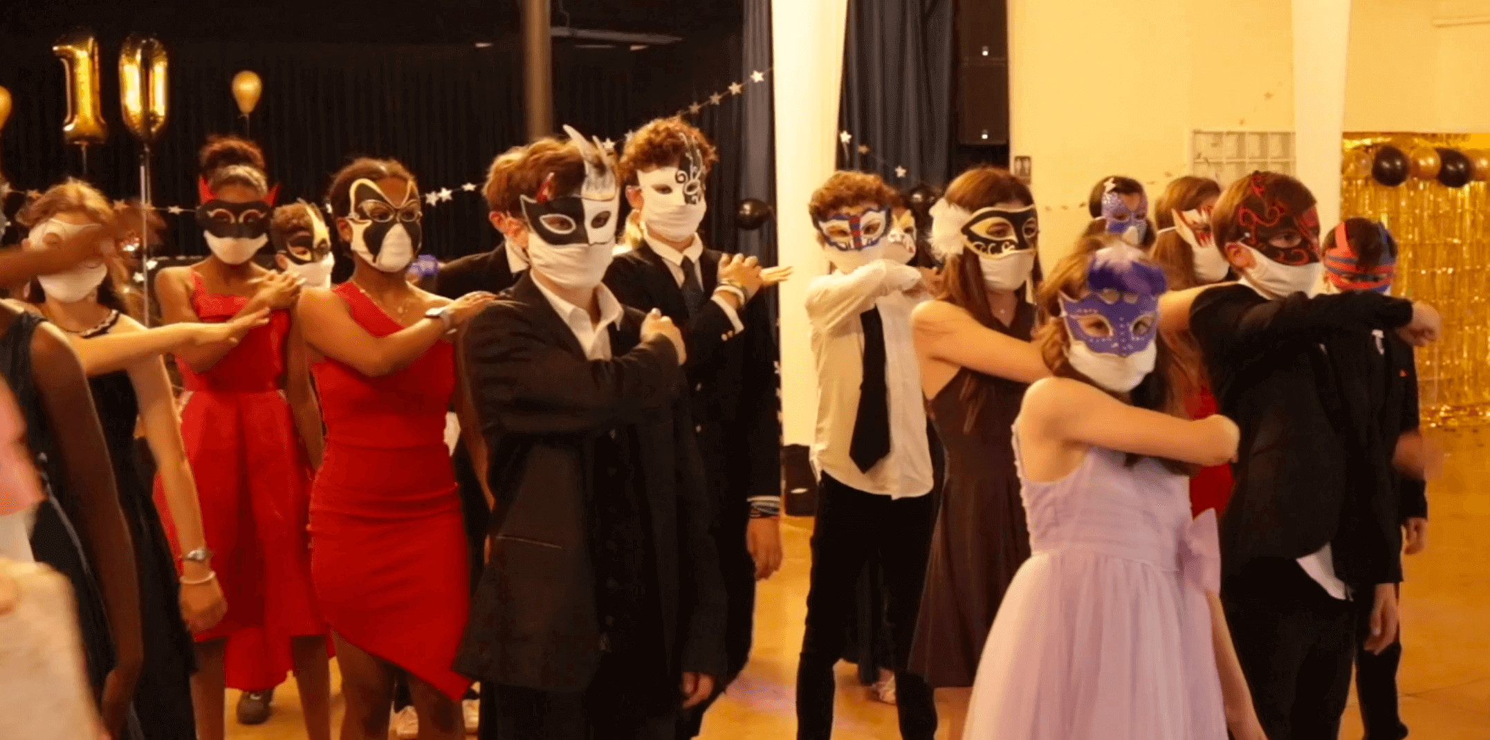 Many students wearing a costumed mask in the musical Face a Face